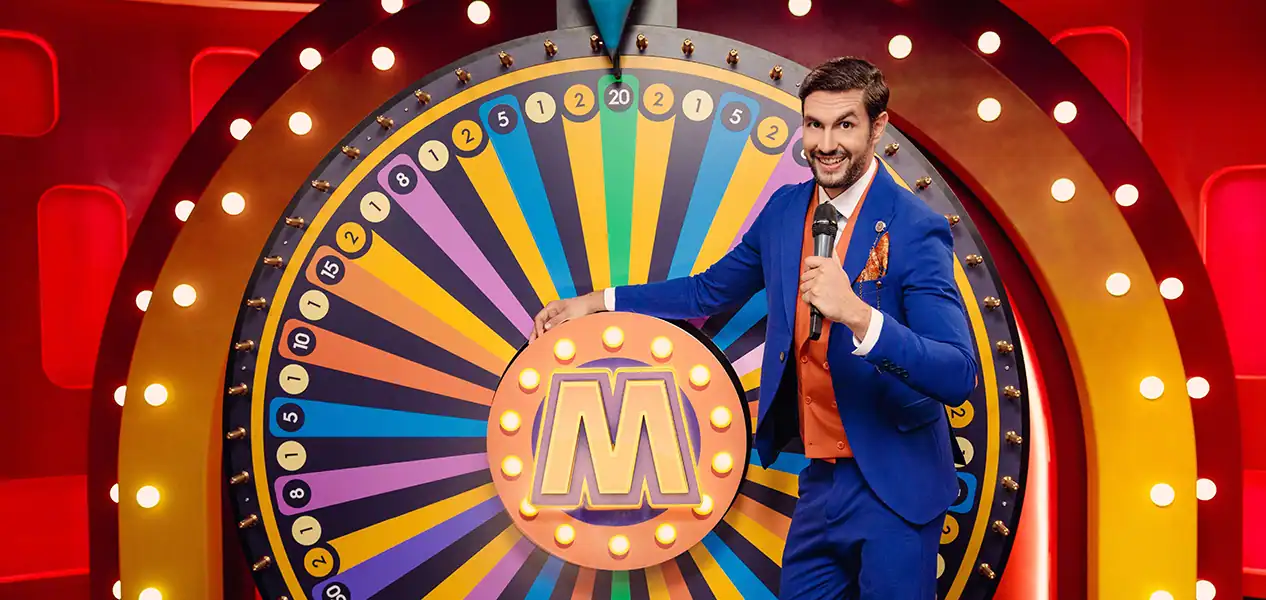 Live presentator die aan het gigantische 54-segmenten Mega Wheel draait.